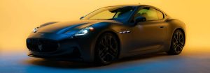 A 2025 Maserati GranTurismo is cast in shadow on a bright yellow background